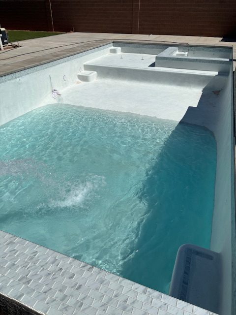 A new pool with a tanning ledge and raised spa filling for the first time.